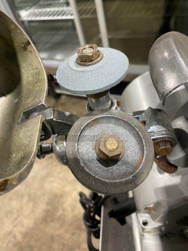 Globe electric countertop deli slicer showing blade adjustment knobs, slight wear. Ideal for commercial use, sturdy legs.