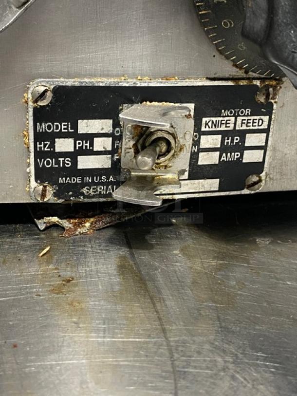 Globe electric countertop deli meat slicer, knife feed, on legs. Model and specs plate visible, showing wear. Made in USA.