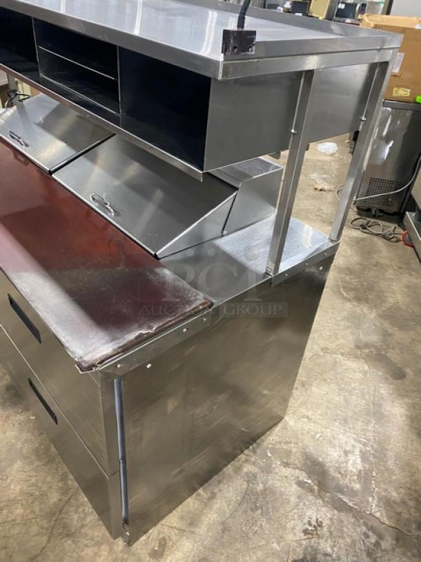 Delfield stainless steel 4-drawer refrigerated prep table, model UCD446N-12-DD5, features overhead storage shelf, 115V, used condition.