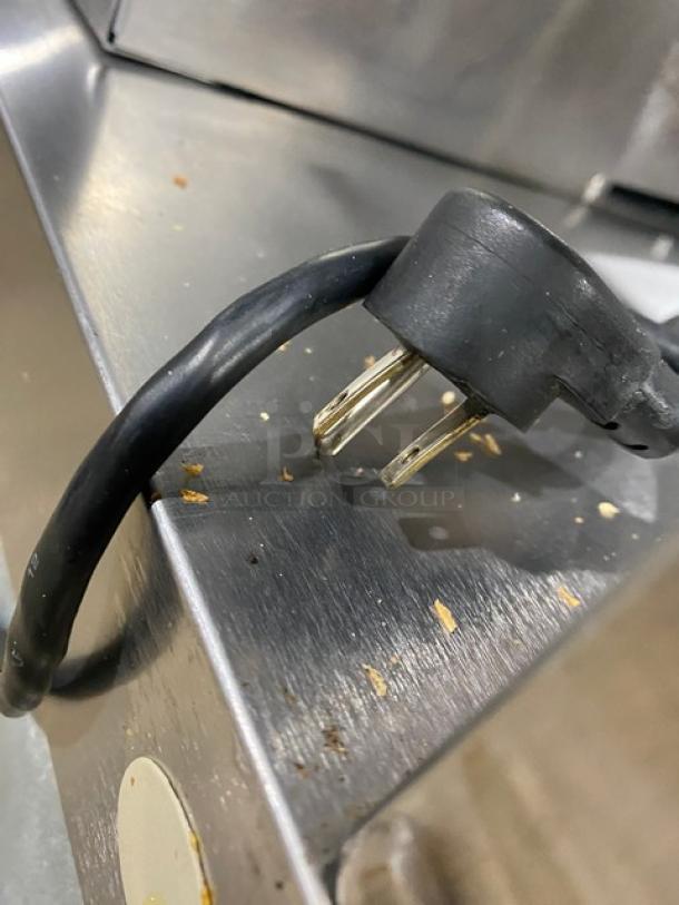 Delfield UCD446N12DD5 stainless steel prep table, 4 drawers, refrigerated, with overhead storage, 115V plug visible.