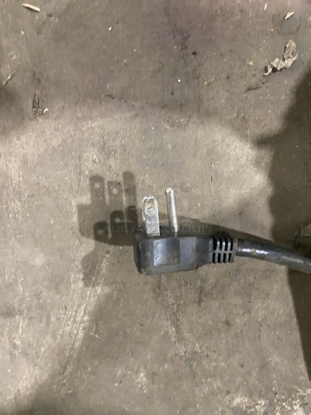 Close-up of a power plug for the Entree CR1ES commercial refrigerator, featuring a grounded three-prong design.