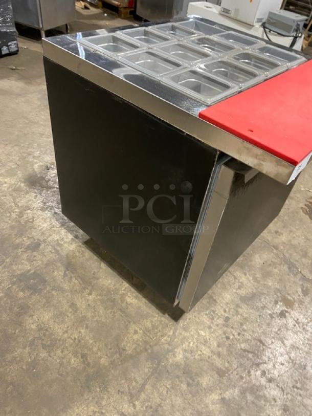 Continental SW3212M black single-door refrigerated prep table, stainless steel top, red cutting board, clear pans, on casters.