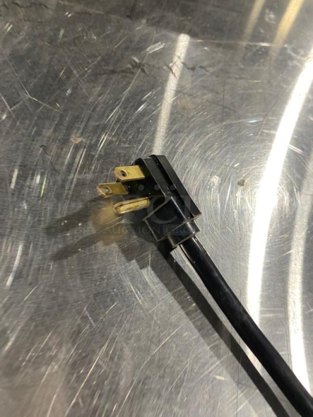 Power plug of Traulsen TU048QC Quick Chiller on stainless steel surface, showing plug design and condition.