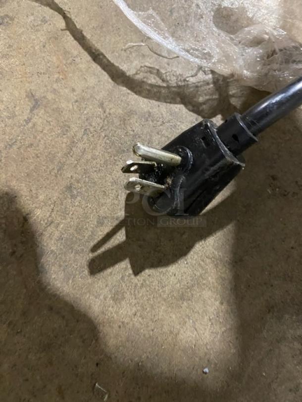 Close-up of the power plug for a GlasTender LP60L6SSLL refrigerated back bar cabinet, showing a three-pronged design.