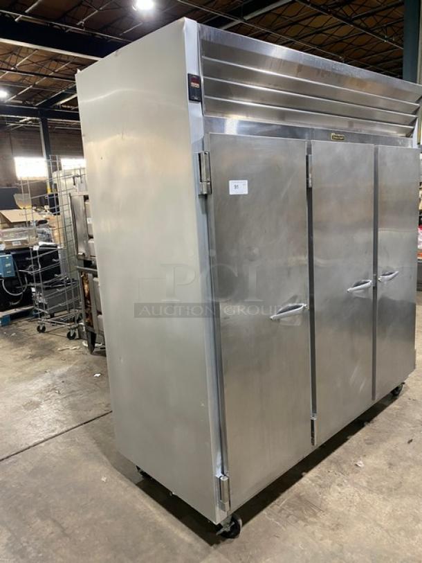 Traulsen G-Series stainless steel 3-door reach-in freezer, model G31011, with poly-coated wire racks, on casters.