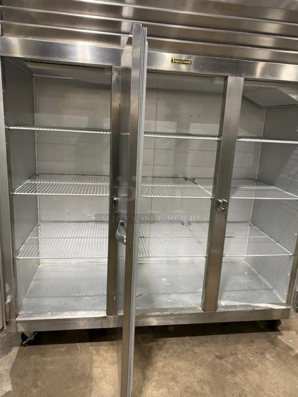 Traulsen G-Series stainless steel 3-door reach-in freezer, model G31011, with poly-coated wire racks, on casters.