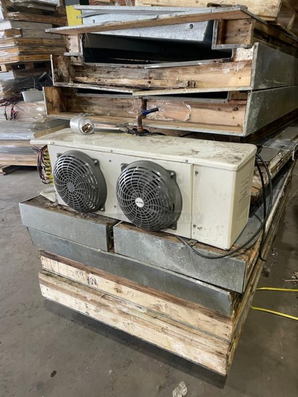 Commercial heavy-duty 8'x8' walk-in freezer with blower, no compressor, visible stacks of metal panels, rust and wear evident.