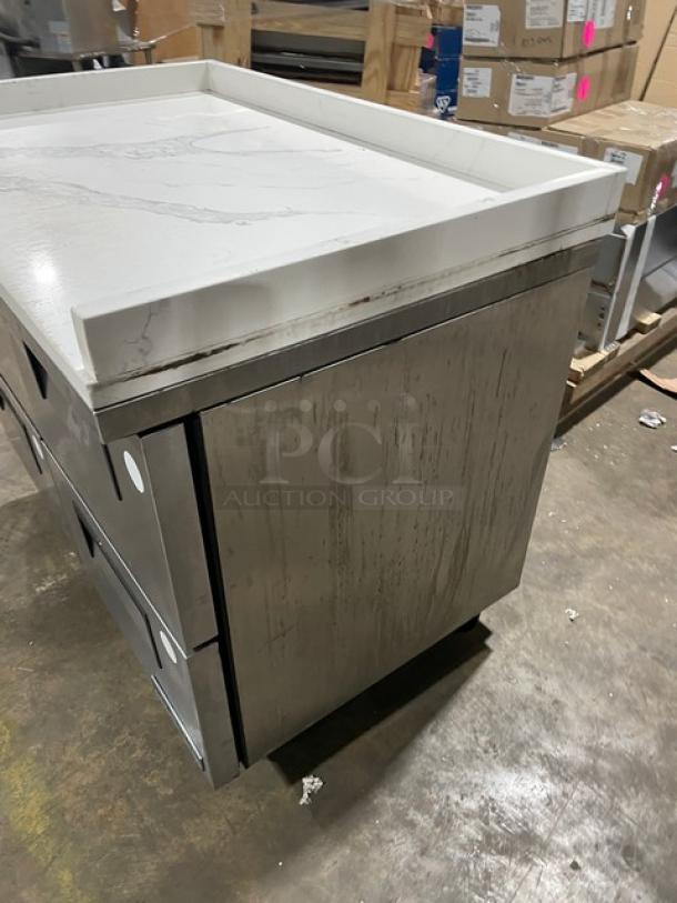 True TUC-48F-D-4-HC undercounter freezer with 4 stainless steel drawers, marble style top, upturned splash, on casters.