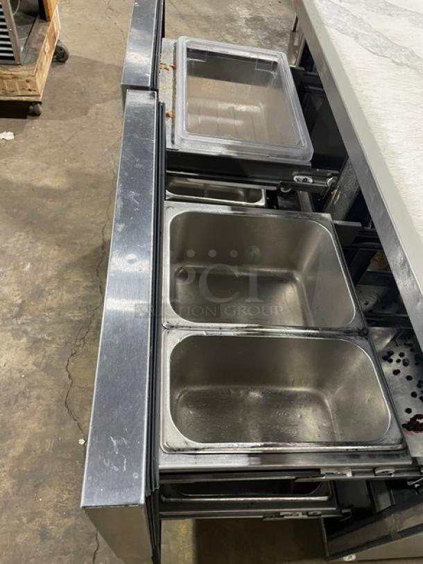 True TUC-48F-D-4-HC 48" stainless steel worktop freezer with marble style top, four drawers, casters, and upturned splash.