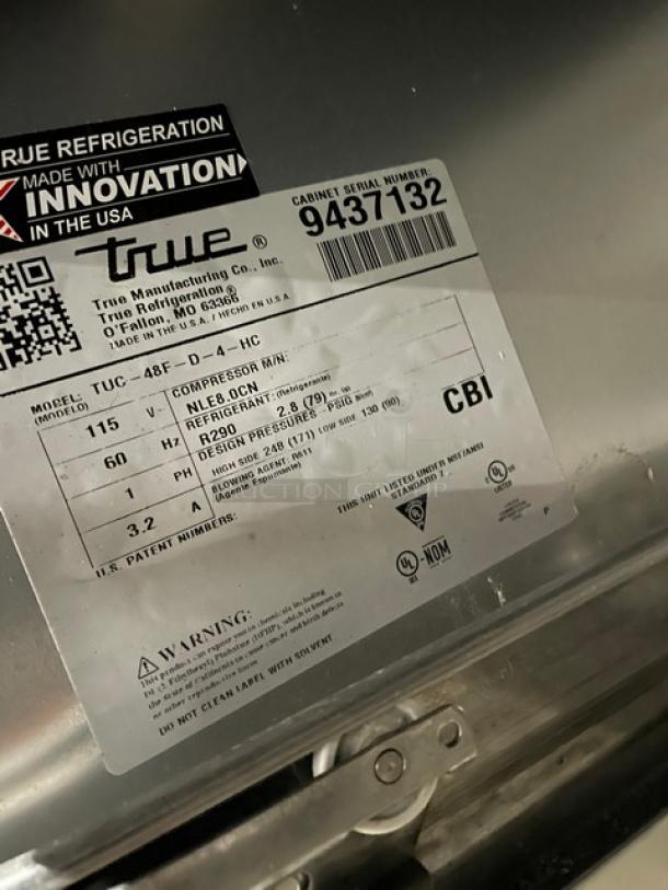 "True TUC48FD4HC label showing model, serial number 9437132, power details, and refrigerant specs on stainless steel surface."