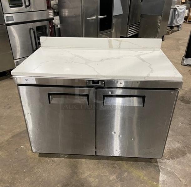 Atosa 2022 stainless steel 2-door undercounter freezer, model MGF8406GR, with marble-style worktop, up-turned backsplash, poly-coated rack, on casters.