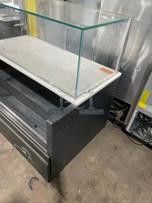 Structural Concepts black refrigerated display case with multi-level open grab-n-go and upper enclosed glass showcase. On legs.