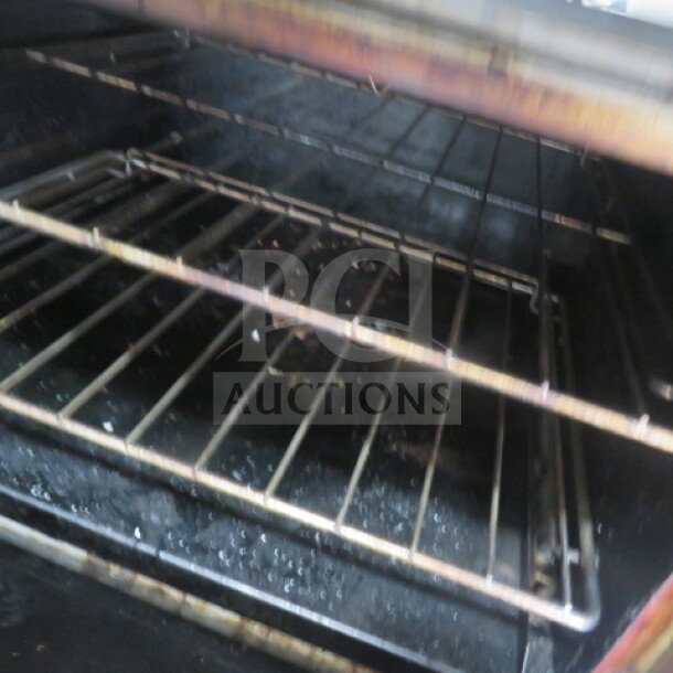 Interior view of Southbend S60DD natural gas range, showing metal racks. Used condition. Model number visible.