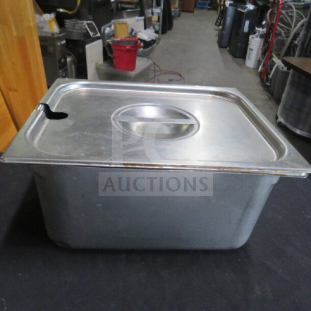 One 1/2 size 6-inch deep hotel pan with lid, stainless steel, used condition, lid with handle and spoon slot.