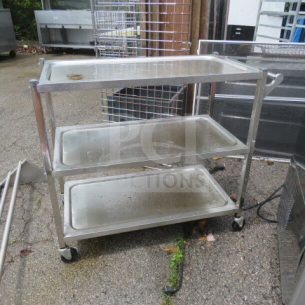 Stainless steel 3-shelf cart on casters, 37.5x17.5x33 inches. Used condition, ideal for transport or storage, sturdy design.