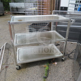 Stainless steel 3-shelf cart on casters, 37.5x17.5x33 inches. Used condition, ideal for transport or storage, sturdy design.