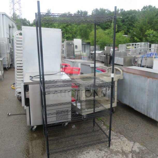Black Metro shelf unit with four wire shelves, measures 36x24x75 inches. Used condition, sturdy storage solution.