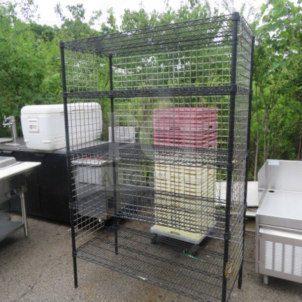 Metro shelf unit with five wire shelves, black metal, size 48x24x75 inches, outdoor setting, slightly used condition.