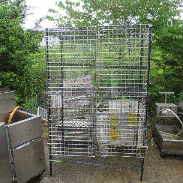 Metro shelf/cage with 5 wire shelves, 48x24x75 inches. Sturdy metal construction, suitable for storage. Outdoor setting.