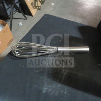 New stainless steel whip on dark surface, polished handle and wires, ideal for culinary use.