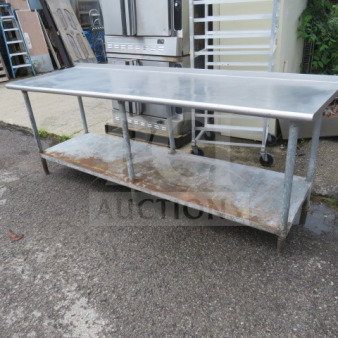 Stainless steel table with under shelf, 96x30x36 inches, shows signs of use; suitable for kitchen or industrial use.