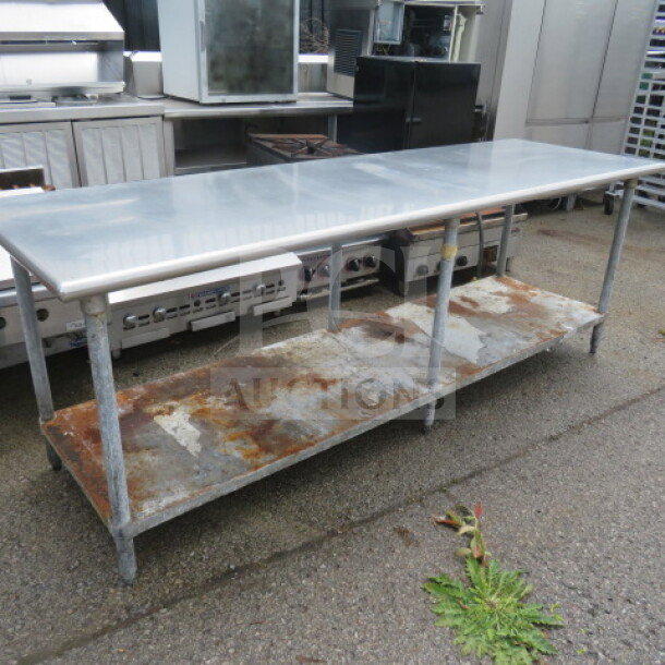 Stainless steel table with under shelf, 96x30x35 inches, showing signs of rust and wear, ideal for industrial use.