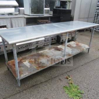 Stainless steel table with under shelf, 96x30x35 inches, showing signs of rust and wear, ideal for industrial use.