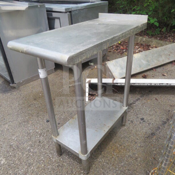 Stainless steel table with under shelf, measuring 15x30x36 inches. Features sturdy legs, ideal for commercial use.