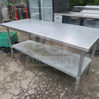 Stainless steel table with under shelf, dimensions 72x30x34 inches. Used condition, visible wear on shelf. Suitable for kitchen use.
