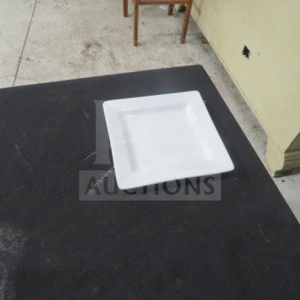 6-inch square white plate by World, model 12XBID, in excellent condition on dark table surface.