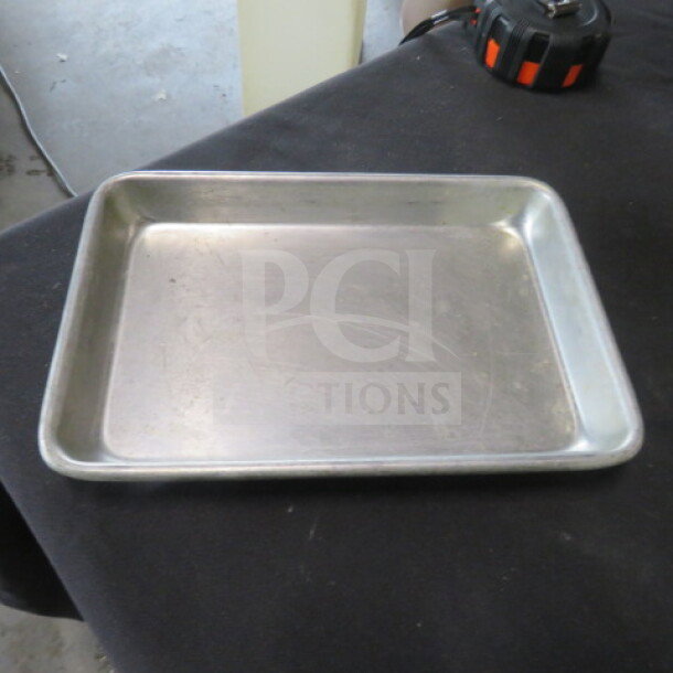 9.5x7 inch aluminum sheet pan, gently used, minor surface scratches. Sturdy build, ideal for baking or roasting.
