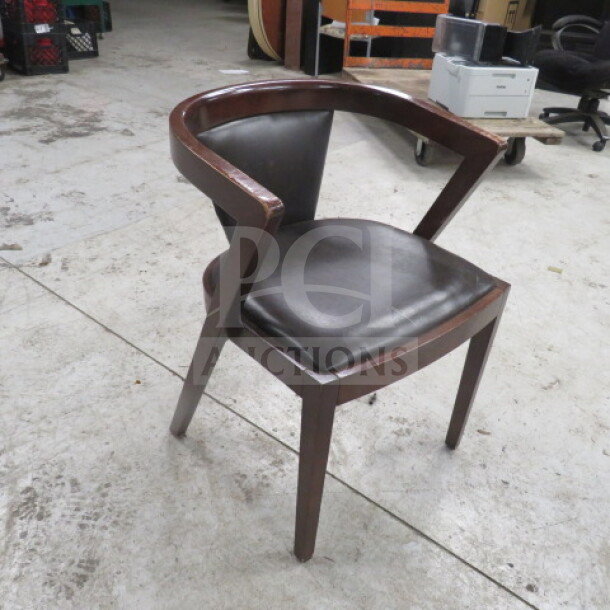 Wooden barrel back chair with cushioned seat and back in good condition, dark finish, modern design, auction price $463.