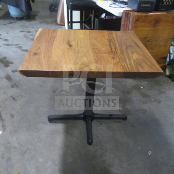 Solid wooden tabletop on pedestal base, 2 inches thick, 24x30 inches. Natural wood finish, excellent condition.