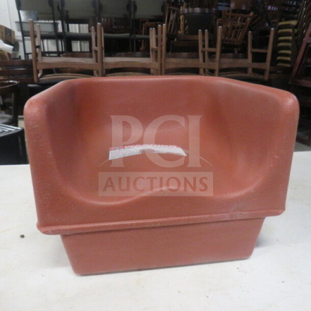Cambro Booster Seat Model 100BC in red. Used condition with visible care label on seat.