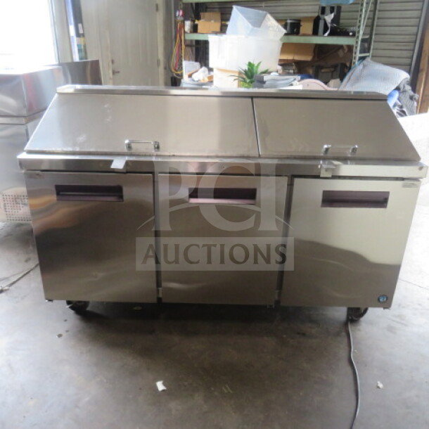 Three-door Hoshizaki refrigerated prep table, model CRMR72-30M, stainless steel, on casters, 72x30x45 inches, with two racks.