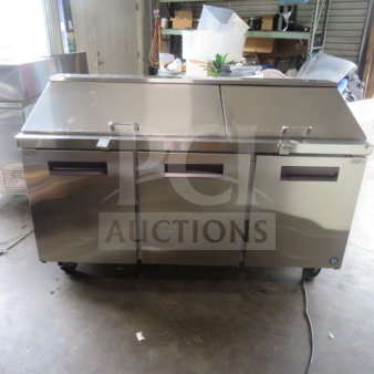 Three-door Hoshizaki refrigerated prep table, model CRMR72-30M, stainless steel, on casters, 72x30x45 inches, with two racks.