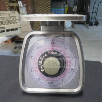 Taylor 5lb Scale, Model TS5, in used condition. Features a large, clear dial display with weight measurements in pounds.