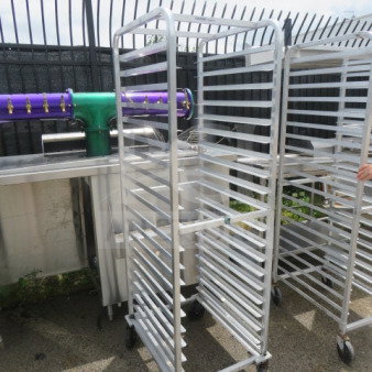 One aluminum speed rack on casters, 20.5x26x70 inches, used condition, multiple tray slots, mobile design.