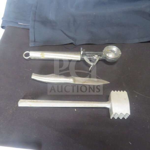 Assorted kitchen utensils including ice cream scoop, knife, and meat tenderizer on black surface, showing signs of wear.