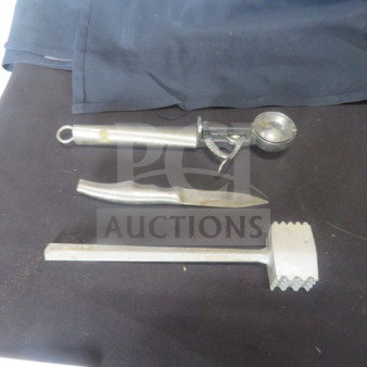 Assorted kitchen utensils including ice cream scoop, knife, and meat tenderizer on black surface, showing signs of wear.