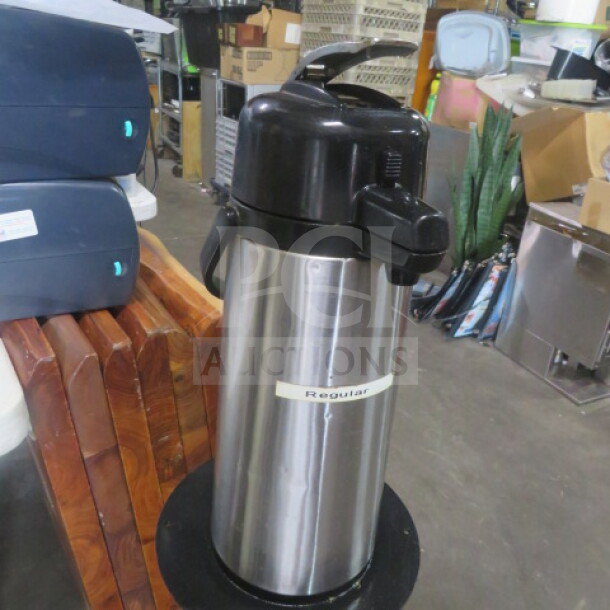 Stainless steel airpot with black lid and spout, labeled "Regular." Good condition, for hot beverages.