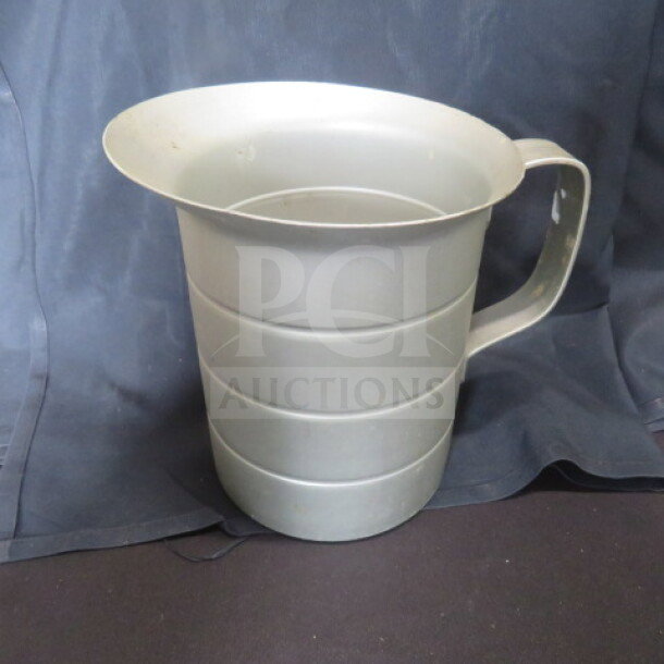 Vollrath 2-quart aluminum measurer, featuring a sturdy handle. Slight wear indicative of previous use.