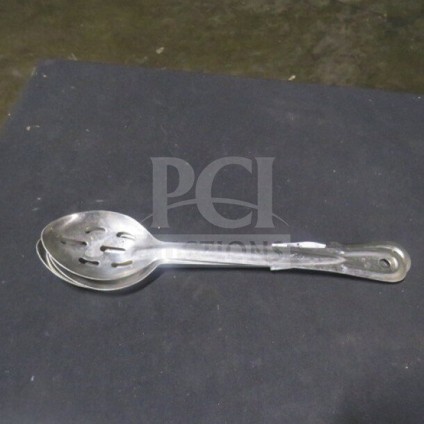 Stainless steel perforated spoon, model 3XBID, in good condition. Features slotted design and a long handle.