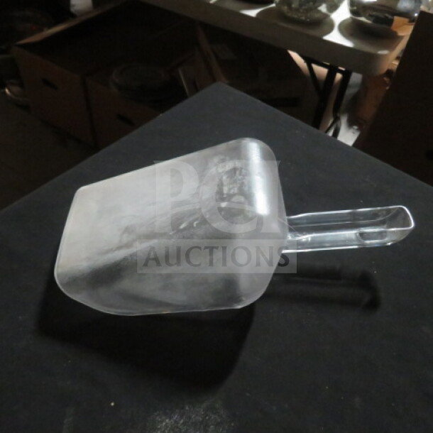 Clear poly scoop with a long handle, gently used, no visible markings or labels, suitable for versatile use.