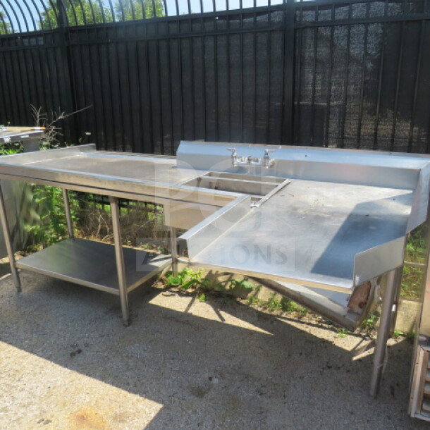 Stainless steel dishwasher table with under shelf, sink, and drain basket. Dimensions: 104"x49"x40". Good condition.