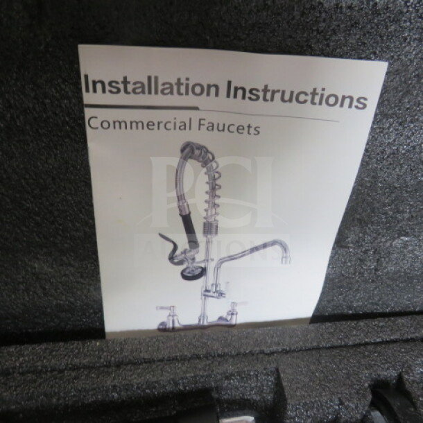 New sink faucet with hose sprayer in packaging, includes commercial faucet installation instructions.