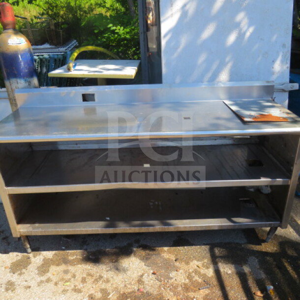 Stainless steel table with backsplash, two under shelves, size 72x24x39.5 inches. Features durable construction and ample storage.