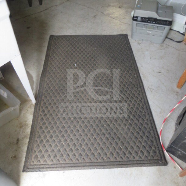 Dark rectangular rug, 60x36 inches, diamond pattern, moderate wear. Ideal for entryway or utility spaces.