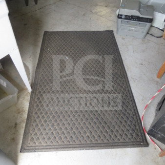 Dark rectangular rug, 60x36 inches, diamond pattern, moderate wear. Ideal for entryway or utility spaces.