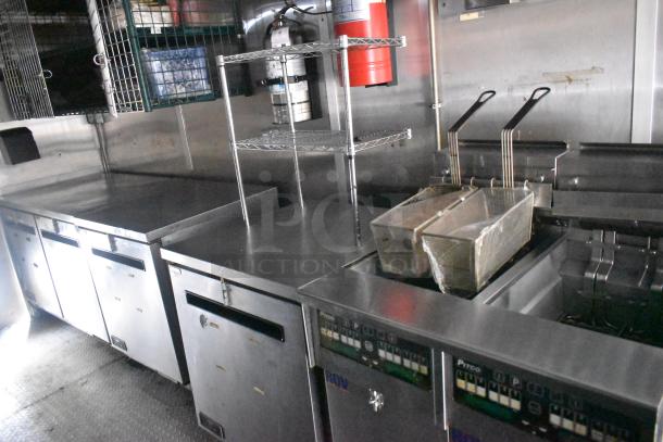 Cruising Kitchens 24' food trailer interior with commercial-grade equipment, stainless steel surfaces, fryers, and storage.